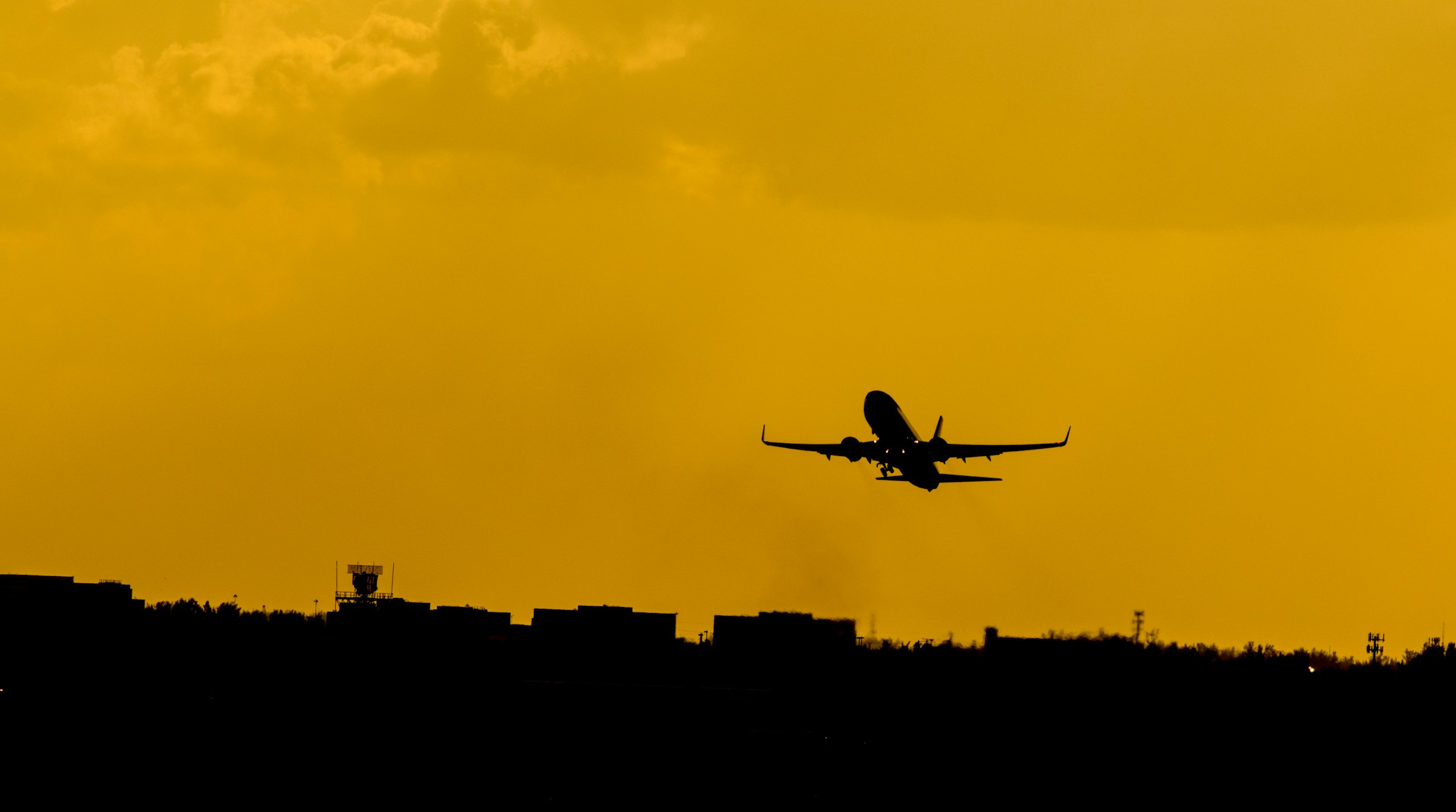 Aircraft taking off against a dramatic sunset sky